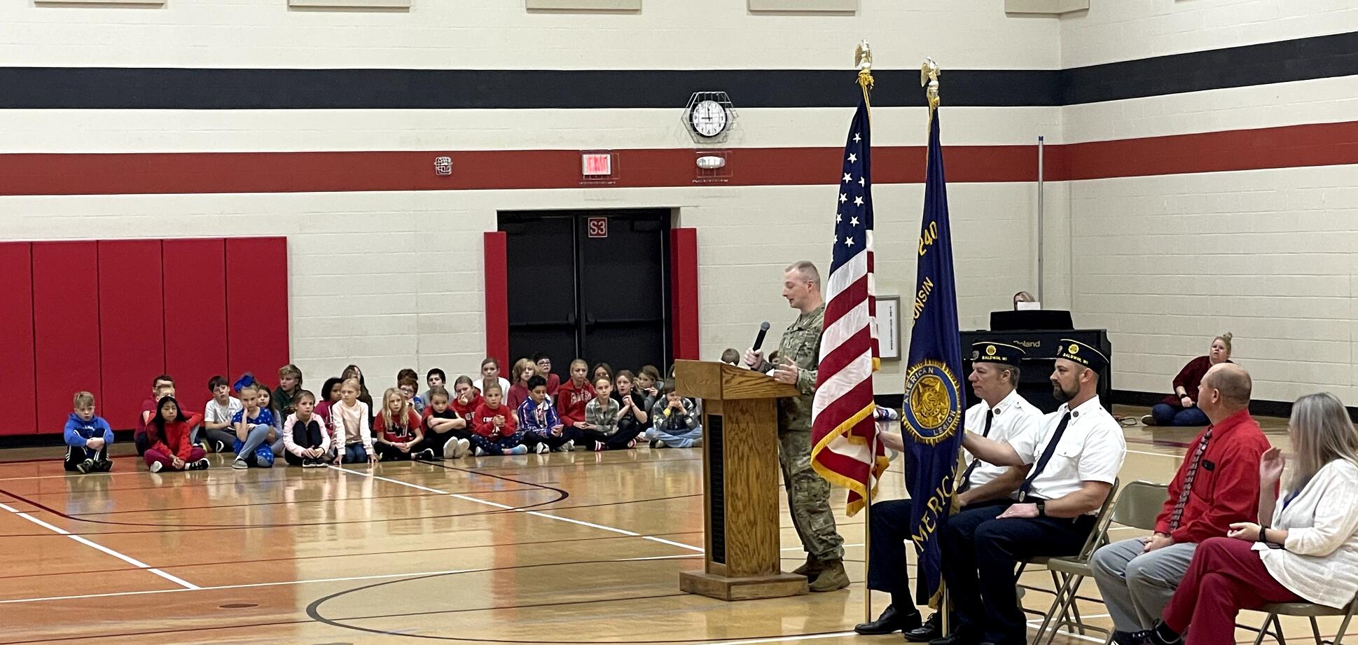 Veterans presenting flag to elementary children.